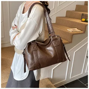 Detail of vintage brown leather Boston bag showing cross-stitch straps and large capacity