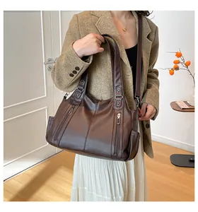 Detail of dark brown litchi pattern tote bag with dual zippers and adjustable strap