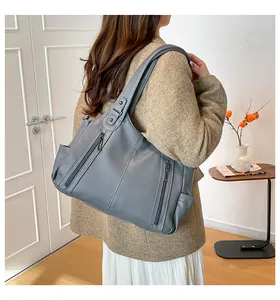 Detailed view of grey tote bag with dual vertical zippers and wide shoulder straps