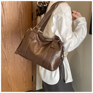 Detail view of wide shoulder strap and metal ring on dark brown vintage shoulder bag