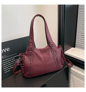 Close-up of deep wine red tote bag showing textured PU leather and silver zipper details