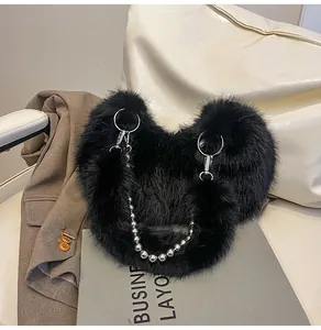 Detail of black faux fur plush bag with silver metal ring handles and beaded chain strap