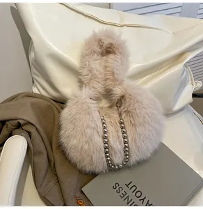 Detailed texture of plush faux fur handbag featuring elegant silver large pearl chain strap