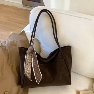 Retro dark coffee tote bag with front pocket and silk scarf on white sofa