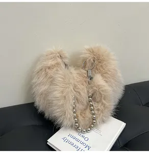 Detail of heart-shaped plush handbag in beige with elegant silver pearl chain strap
