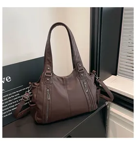 Detail of dark brown lychee textured tote bag with metal zippers and side pockets
