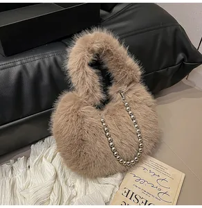 Detail of khaki heart-shaped plush bag with a silver pearl chain on vintage background