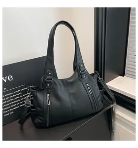 Detail of black lychee grain leather tote bag with vertical zippers and side pockets