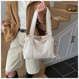 Detailed close-up showing the creamy white PU leather texture of the Boston shoulder bag