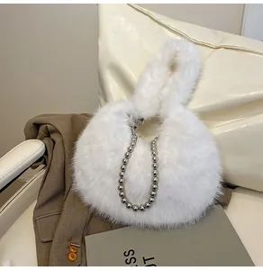 Detail view of a white faux fur plush handbag featuring a chic silver metallic ball chain