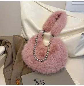 Detail of pink faux fur handbag with stylish silver pearl metal chain and plush handle