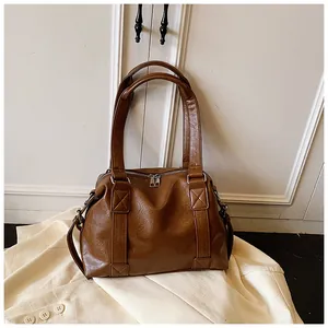 Detail view of vintage brown bag showing natural leather texture and silver zippers