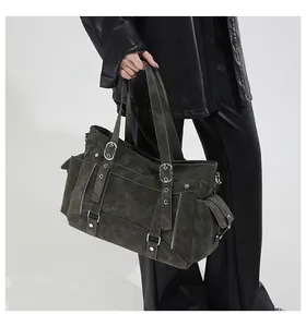 Detail der olivgrünen Ledertasche mit funktionalen Taschen und silbernen Metallschnallen