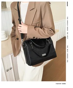 Detail of black leather Boston bag featuring silver metal buckle and soft textured finish