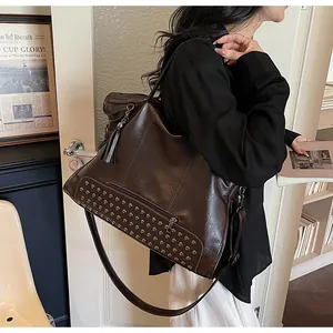 Nahaufnahme einer dunkelbraunen Ölwachs-Leder-Tote mit Nieten und Quasten-Detail