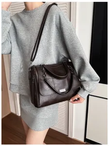 Detailed view of the dark brown leather texture and silver metal accents on the Boston bag