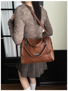 Close-up of vintage brown leather Boston bag with metal lock and stitching details