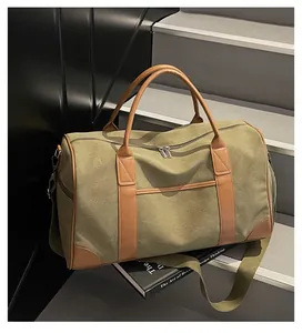 Nahaufnahme der militärgrünen Reisetasche aus Canvas mit Ledergriffen auf Steinstufen