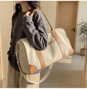 Reisetasche aus Segeltuch mit braunem Lederbesatz und abnehmbarem Schultergurt-Detail