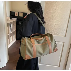 Modell mit großer armee-grüner Canvas-Reisetasche, braunen Ledergriffen und Schultergurt