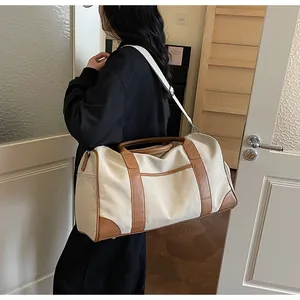 Detail der Canvas-Reisetasche mit brauner Lederverstärkung und robusten Metallbeschlägen
