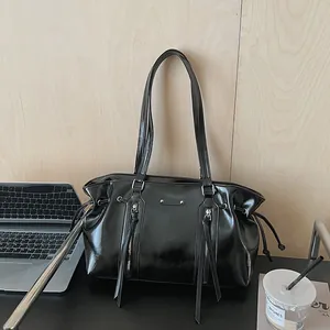Vintage oil wax leather tote bag in shiny black with drawstring and tassel details