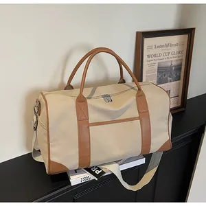 Detailansicht der großen Canvas-Reisetasche mit braunem Lederbesatz und Griffen