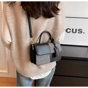 Close-up of color-block crossbody bag with gold hardware and fashion tag detail
