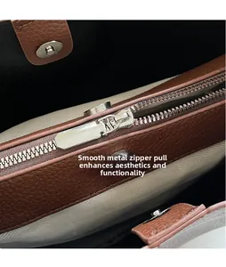 Details des silbernen Reißverschlusses und Fischgräten-Stofffutters der braunen Tasche