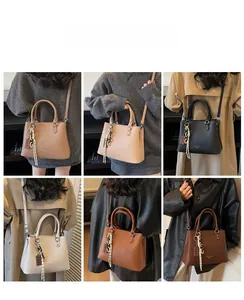 Détail montrant les couleurs des sacs à main en cuir grainé avec pompons et breloques