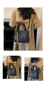 Détails du sac à main en cuir grainé noir avec pendentif de mode sur la poignée