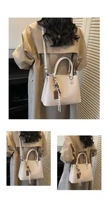 Détail du sac cabas en cuir crème à texture litchi avec poignées et breloques décoratives
