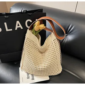 Détail du sac seau au crochet avec anses en cuir marron et tulipes jaunes décoratives