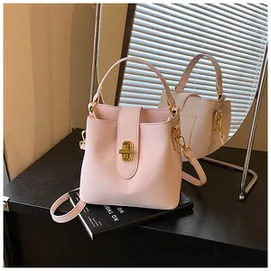 Detail of pink faux leather bucket bag with gold clasp and mirror reflection display