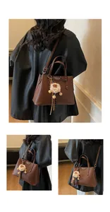 Detail of dark brown lychee textured bag with plush beige ball and Fashion Bag plaque
