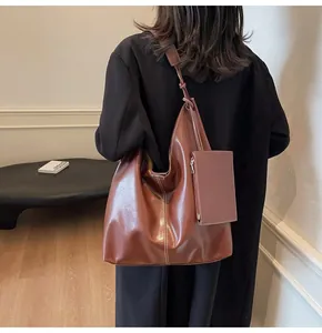 Detail view of large brown faux leather tote bag with contrast stitching and pouch