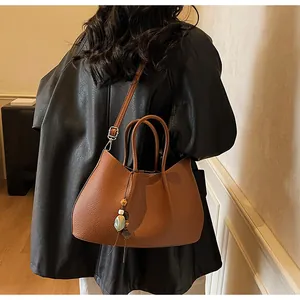 Braune Shopper-Tasche aus Kunstleder mit runden Griffen und Anhänger aus Perlenquasten