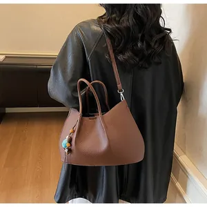 Detailansicht braune Shopper-Tasche aus Leder mit buntem Perlenanhänger und Falten-Design