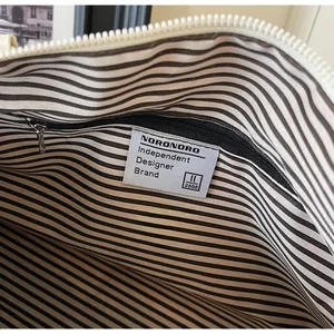 Detail view of tote bag striped interior lining and internal zipper pocket design
