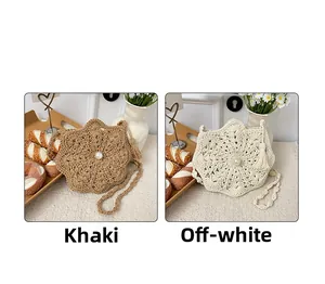 Detail of woven straw bags in khaki and cream with pearl decor and side tassels