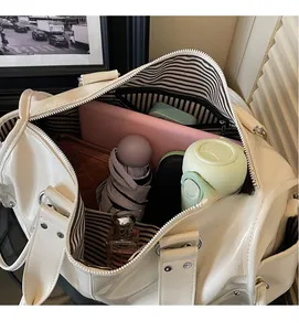 Top view of spacious white travel handbag with striped lining and organized daily items