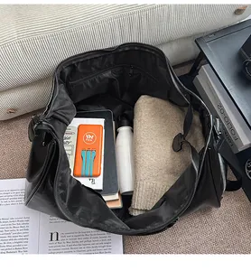 Close-up of the spacious interior of the black PU travel bag showing large capacity storage