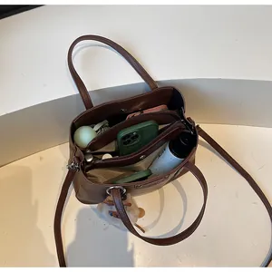 Brown lychee leather crossbody bag showing internal compartments and large capacity