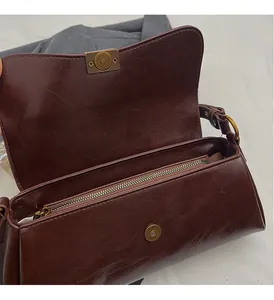 Dettaglio borsa a tracolla vintage marrone rossiccio lucida con chiusura magnetica bronzo