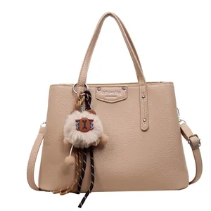 Beige lychee pattern leather tote bag with silver hardware and plush pendant decoration