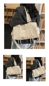 Detail of a large cream patent leather tote bag with glossy finish and side lace-up design