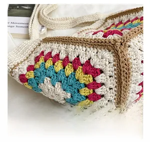 Detailed close-up of handmade crochet tote bag featuring multi-color floral stitch patterns