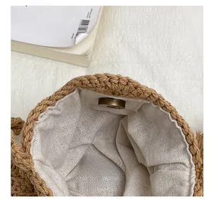 Detail of woven straw bag interior with light lining and secure magnetic snap closure