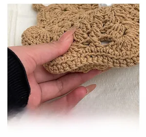Macro detail of hand-woven straw shoulder bag with elegant white pearl accent decoration