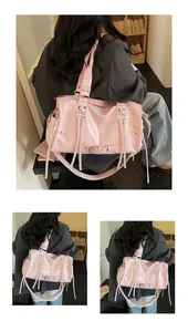 Detailed close-up of pink glossy tote bag featuring side tassels and cross-strap details